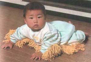 laying baby with mop on babygro