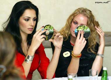 two females checking themselves out in the reflections from cds