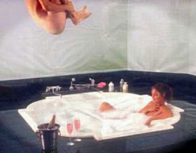 man dive bombing bath with woman in it
